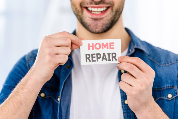 cropped image of smiling handsome man holding home repair card   - Фото, изображение