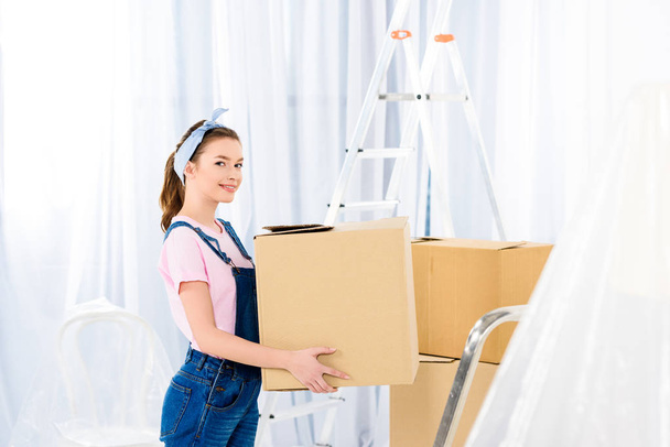 happy girl standing with box and looking at camera - 写真・画像