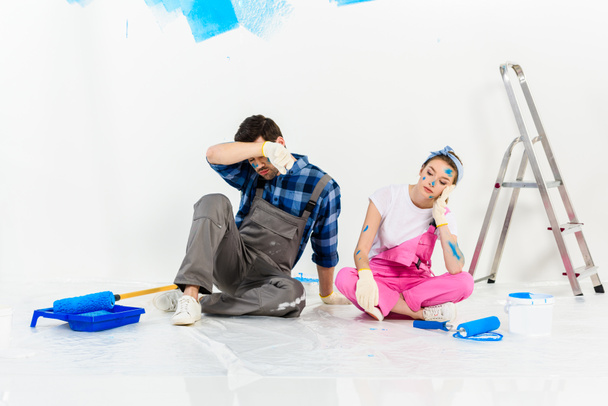 moe vriendje en vriendin zittend op de vloer tijdens reparaties - Foto, afbeelding