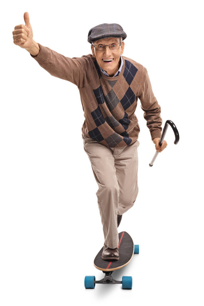 senior riding a longboard and making a thumb up gesture - Foto, Imagen