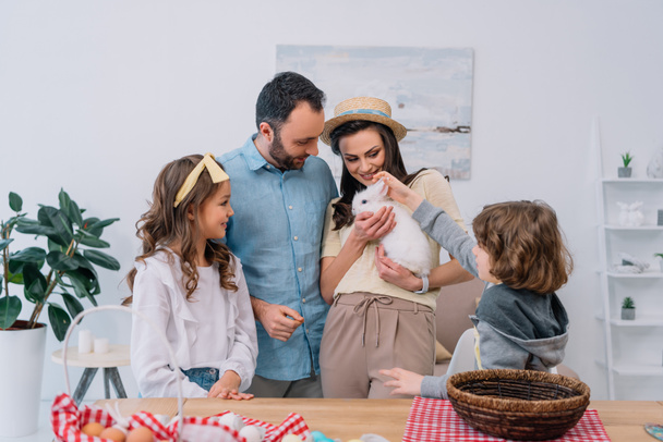 glückliche junge Familie mit schönem weißen Hasen zu Hause - Foto, Bild