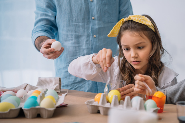 beautiful child painting easter eggs with father - Photo, Image