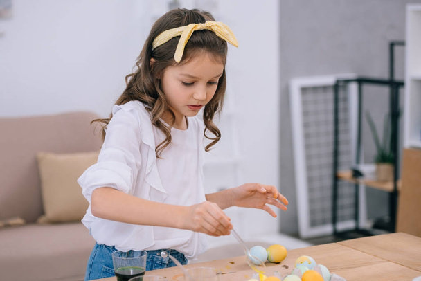 focused little child painting easter eggs - Fotó, kép