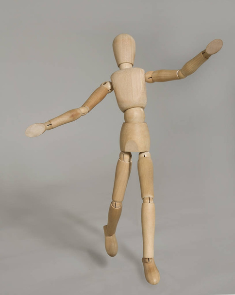 puppet in motion on grey background - Φωτογραφία, εικόνα