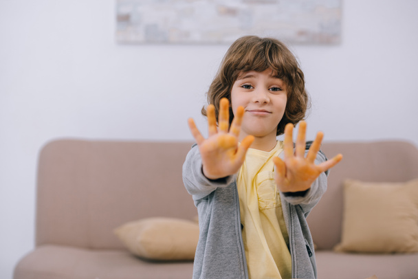 bambino felice mostrando le mani sporche dipinte di giallo
 - Foto, immagini