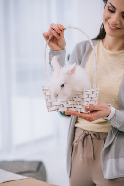 attractive young woman with white rabbit in basket - Fotó, kép