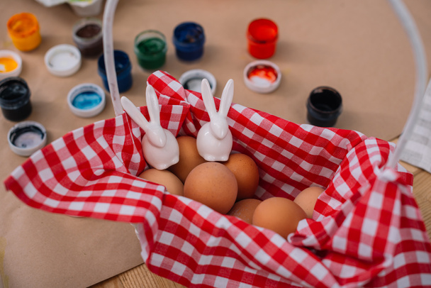 easter eggs with rabbits figures in basket - Φωτογραφία, εικόνα
