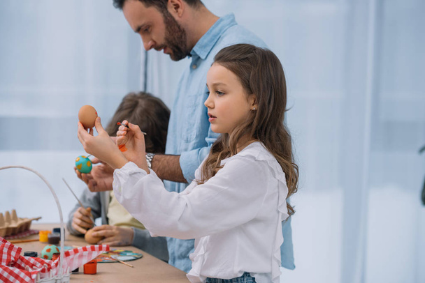 father painting easter eggs with adorable little children - Photo, Image