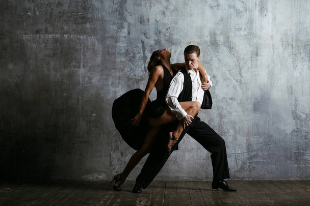 Young pretty woman in black dress and man dance tango - Φωτογραφία, εικόνα