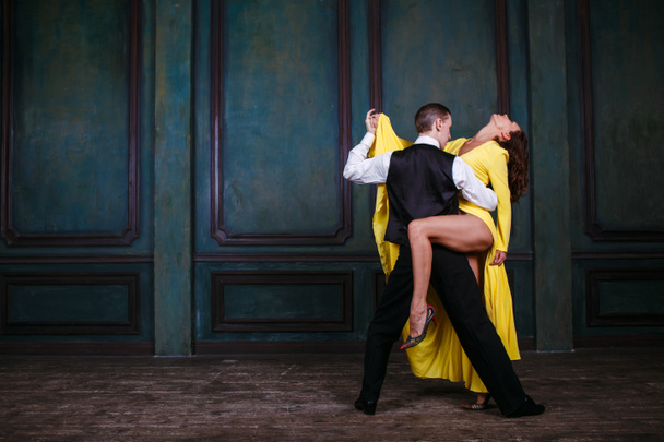 Joven bonita mujer en vestido amarillo y hombre baile tango
 - Foto, Imagen