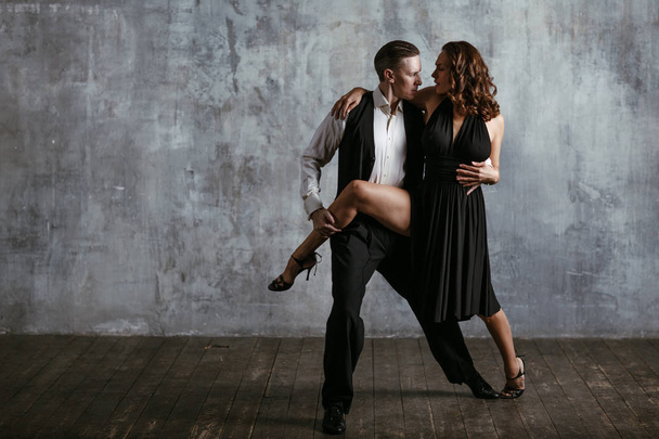 Young pretty woman in black dress and man dance tango - Photo, Image