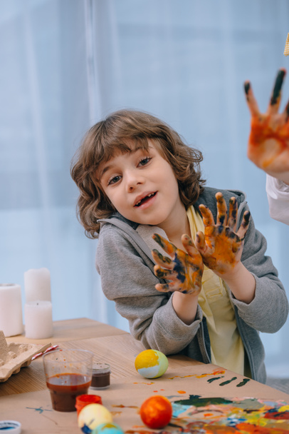μικρό παιδί δείχνει τα χέρια του βρώμικα πολύχρωμο σε κάμερα - Φωτογραφία, εικόνα