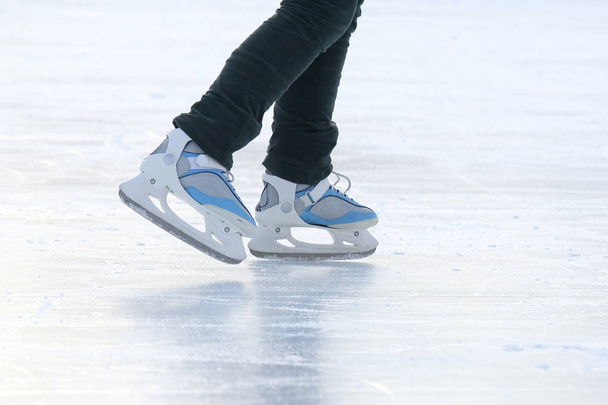 pies en los patines de una persona rodando en la pista de hielo - Foto, Imagen