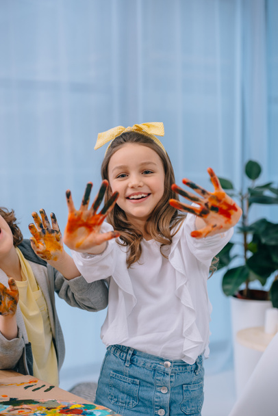 adorables niños felices mostrando sus manos de colores en pintura
 - Foto, imagen