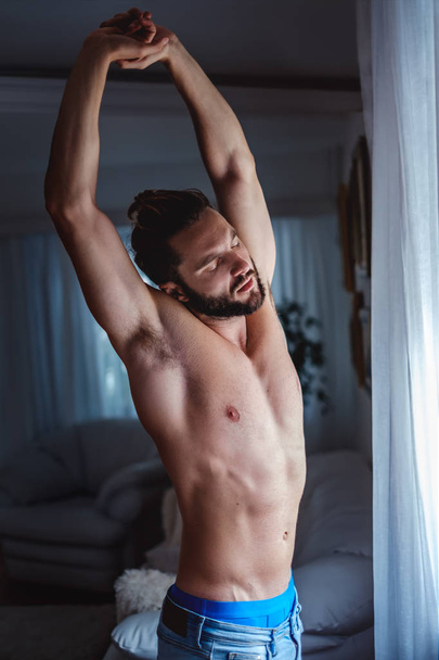 Мужчина без рубашки, утренняя рутина у окна
 - Фото, изображение