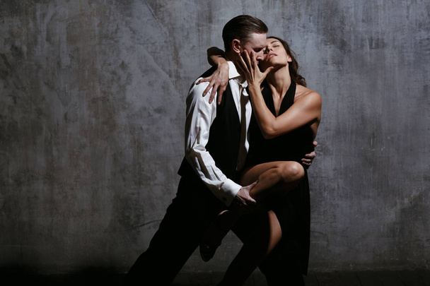 Młoda ładna kobieta w czarnej sukni i człowiek tańca tango - Zdjęcie, obraz