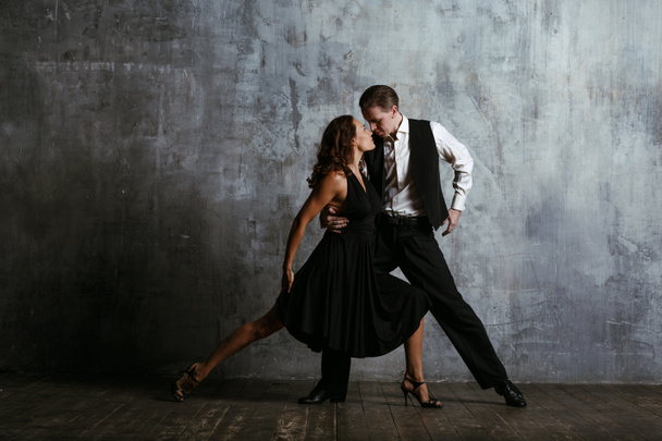Young pretty woman in black dress and man dance tango - Fotografie, Obrázek