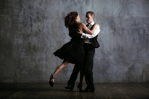 junge hübsche Frau in schwarzem Kleid und Mann tanzen Tango - Foto, Bild