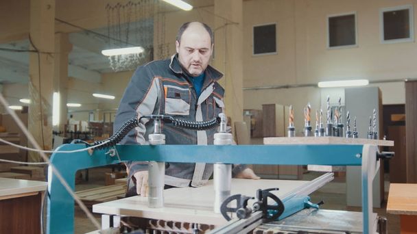 Рабочий плотник разрезал деревянную деталь на мебельной фабрике
 - Фото, изображение