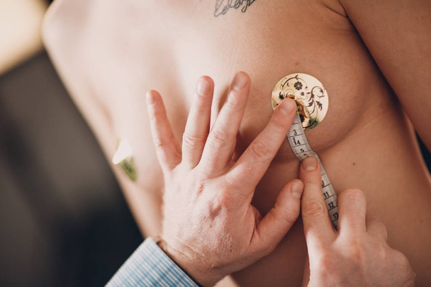 Chirurgia plastyczna kobiece kobieta lekarz bada blond kobieta kształt piersi pacjenta - Zdjęcie, obraz