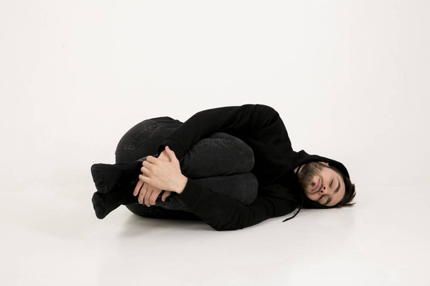 jovem atraente em roupas pretas com um capuz em sua cabeça li
 - Foto, Imagem
