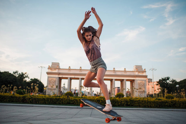 Jeune femme sportive chevauchant sur le longboard dans le parc
 - Photo, image