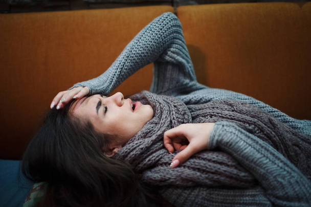 Objawem grypy zimnej lub alergii. Chory młoda kobieta z gorączką kichanie w tkance, alergie, przeziębienie, leżąc na łóżku z szalik. - Zdjęcie, obraz