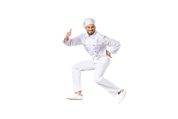 happy male chef showing thumb up and smiling at camera isolated on white  - Foto, Imagen