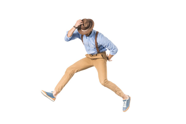 hombre joven con estilo en el salto del sombrero aislado en blanco
  - Foto, Imagen