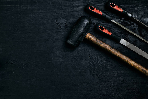 Серия из многих острых стальных лезвий и молоток на черном деревянном фоне
 - Фото, изображение