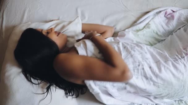 Woman wake up in morning lying on bed, top view - Filmagem, Vídeo