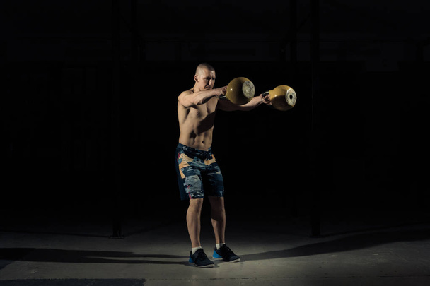 A strong man picks up kettlebell in gym. Sportlife - Photo, image
