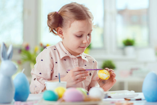 Happy pretty child girl having fun during painting eggs for east - Foto, imagen
