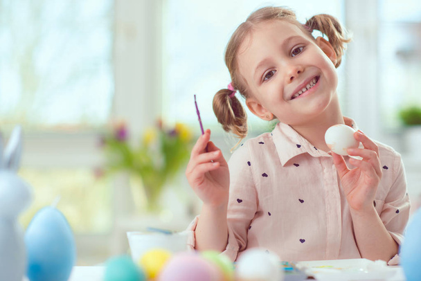 Happy pretty child girl having fun during painting eggs for east - Photo, Image