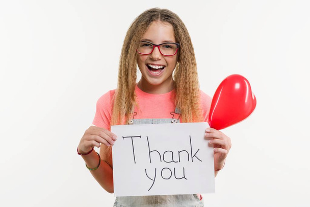 A teenage girl holding a paper with a thank you text, and a heart balloon - Foto, immagini