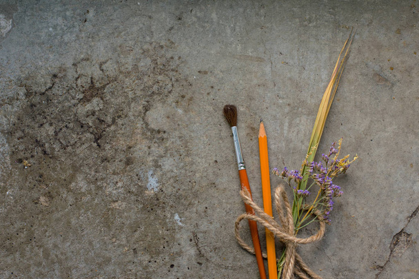 Pomůcky pro psaní a kreslení s kyticí levandule, na ocncrete pozadí, ploché lay - Fotografie, Obrázek