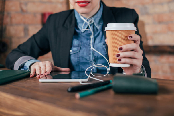Krásná mladá žena freelancer s Poznámkový blok a tablet mají přestávku na kávu v interiéru místnosti podkroví - Fotografie, Obrázek