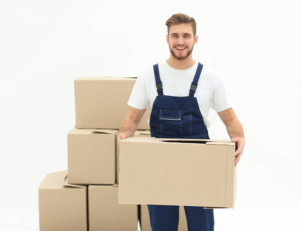 Young man carrying a box to the pile of boxes. - Photo, Image