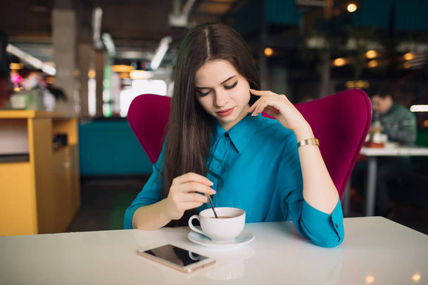 Strict business woman in suit sitting and having break in a futuristic cafe - Foto, Imagen
