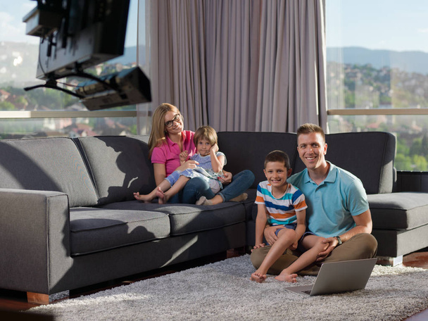 fiatal boldog család pihentető otthon laptop és tablet számítógépeket használó luxury living Room - Fotó, kép