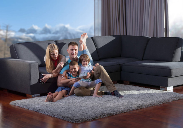 Onnellinen nuori perhe leikkii yhdessä tabletin kanssa kotona istuu sohvalla - Valokuva, kuva