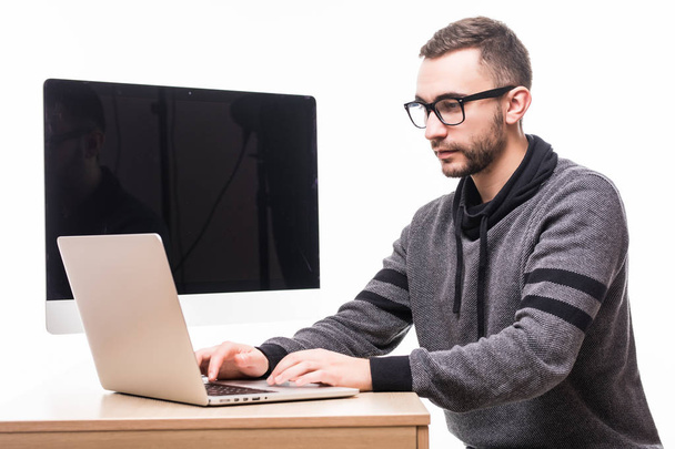 Hombre guapo en gafas que trabajan en el ordenador portátil con pantalla de monitor en la espalda
 - Foto, imagen