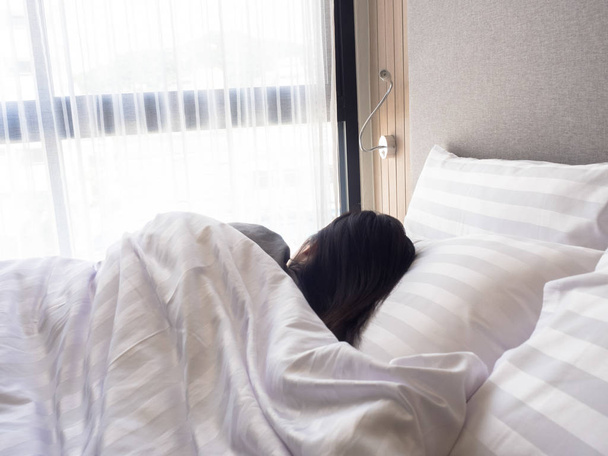 Nő nyújtás az ágyban, ébredés után, hátsó nézet - Fotó, kép