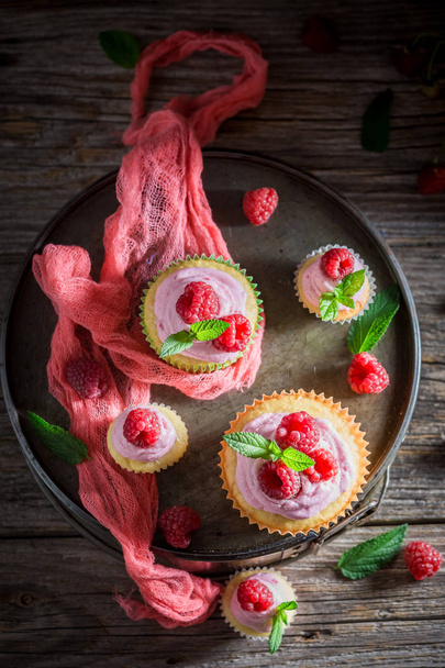 Delicious and tasty raspberry muffin with berries and pink cream - Фото, изображение