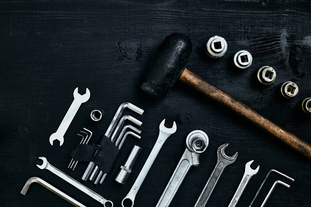 Colocação plana de conjunto de ferramentas para reparação de automóveis, tais como chaves sobre fundo de madeira preta. Vista superior
. - Foto, Imagem