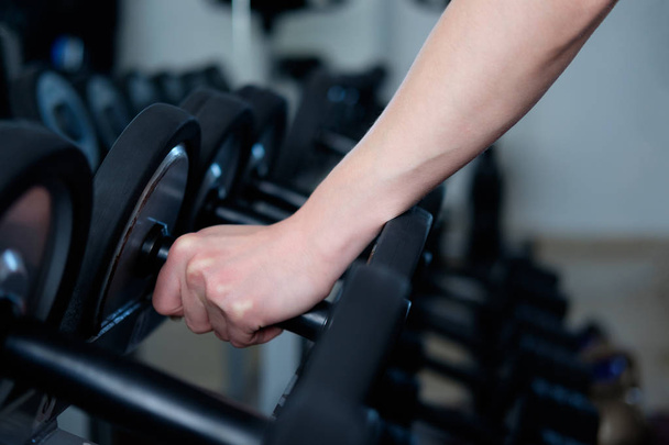 Human's hand, taking dumbbell in gym - Foto, imagen