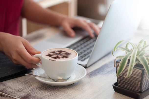 Jonge vrouw freelancer te typen in de laptop in café - Foto, afbeelding