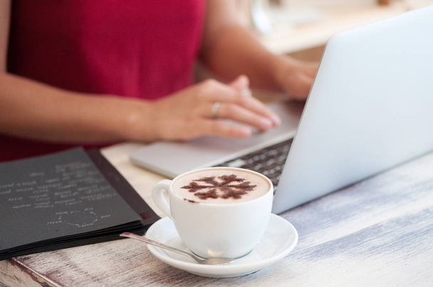 junge Freiberuflerin tippt in Laptop in Café - Foto, Bild