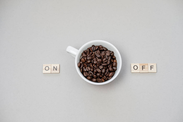 Cup of coffee switching on grey background. Top view, flat lay - Foto, imagen
