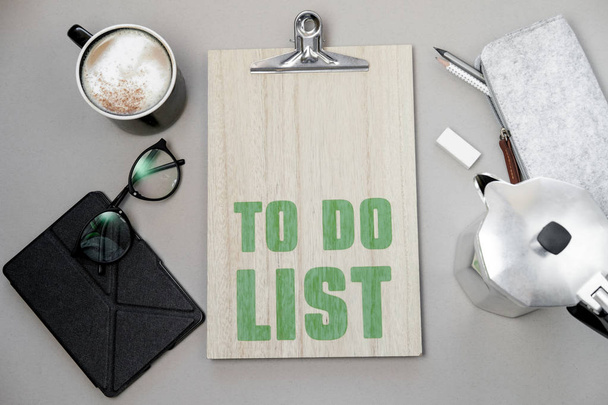 Coffee cup and to do list on grey desk from above, planning and design concep - Фото, изображение